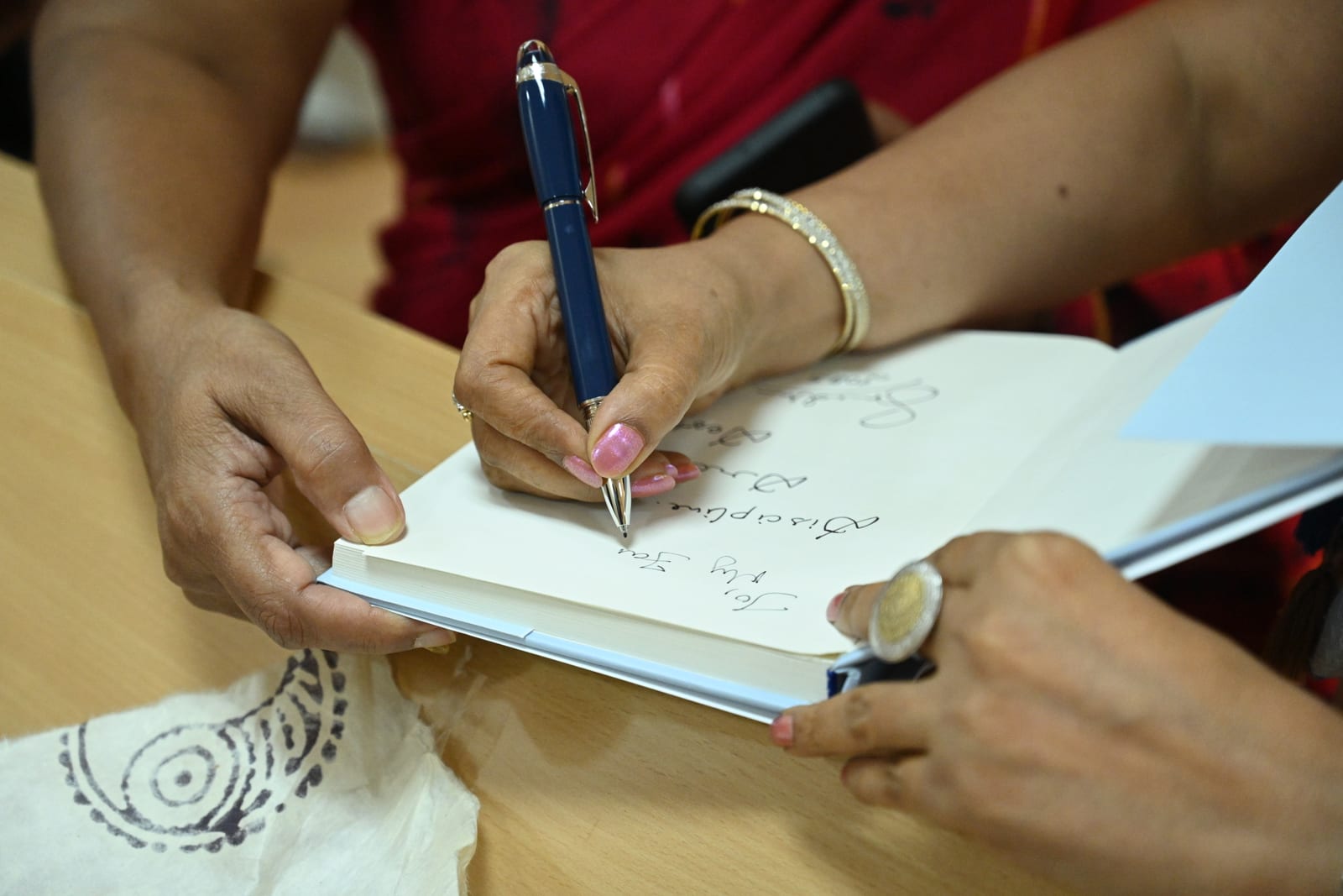 Madhu Sarda signing a copy of Everest Awakenings for an ACME attendee at the close of the event